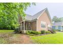A charming one story home with light pink siding and stone accents, with lush foliage and a covered porch at 2378 Randall Ave, Lithonia, GA 30058