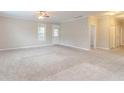 Spacious living room with neutral carpet and walls, featuring a ceiling fan and bright, natural light at 2378 Randall Ave, Lithonia, GA 30058