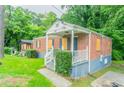 Attractive brick home with a welcoming front porch and manicured bushes at 2817 Burton Nw Rd, Atlanta, GA 30311