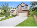 Two-story home with brick and siding features a spacious driveway and well maintained landscaping at 545 Offaly Ln, Atlanta, GA 30349