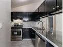 Modern kitchen featuring granite counters, stainless steel appliances, and dark cabinets at 2654 Laurel View Dr, Snellville, GA 30039