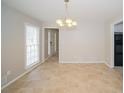 Neutral dining area featuring tile floors, modern chandelier, and a view of the front door at 2799 Lake Jodeco Rd, Jonesboro, GA 30236