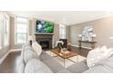 Cozy living room with a fireplace, large windows, and comfortable gray sofa at 3900 Danube Ln, Atlanta, GA 30339