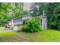 A two-story home showcasing a stone facade, attached garage, and lush landscaping, with green trees at 4766 White Oak Path, Stone Mountain, GA 30088