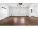Bright living room with hardwood floors, neutral walls, ceiling fan, and windows bringing in natural light at 6535 Buckhurst Trl, Atlanta, GA 30349