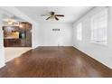 Open-concept living room with dark hardwood flooring and views of the adjacent kitchen at 6535 Buckhurst Trl, Atlanta, GA 30349
