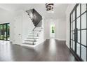 Bright foyer features dark wood floors, glass-railed staircase, and stylish lighting at 115 Thome Dr, Alpharetta, GA 30022