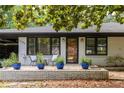Inviting front porch with stone accents, potted plants, and charming seating area at 1195 Russell Dr, Decatur, GA 30030