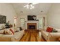 Bright living room featuring hardwood floors, a brick fireplace, and comfortable seating at 160 Vinnys Way, Covington, GA 30014