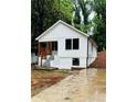 Inviting exterior showcasing a board and batten facade, small porch and concrete driveway with wet weather at 2004 Detroit Nw Ave, Atlanta, GA 30314