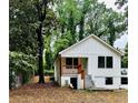 Charming exterior with board and batten siding, a cozy porch with wooden details, and lush greenery surrounding it at 2004 Detroit Nw Ave, Atlanta, GA 30314