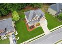 Aerial view of a beautiful brick home with a pristine lawn and mature trees at 927 Ivey Chase Pl, Dacula, GA 30019