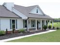 Lovely single-story home featuring a welcoming covered porch, complemented by landscaped garden beds and gray shutters at 2980 Hd Atha Rd, Covington, GA 30014