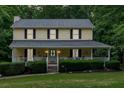 Charming two-story home with a covered front porch, manicured lawn, and mature landscaping at 40 Picketts Forge W Dr, Acworth, GA 30101
