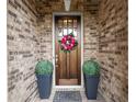 Inviting front door with a wreath, flanked by potted plants, set in a brick surround at 4137 Avid Park, Marietta, GA 30062