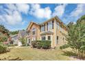 View of a two-story home showing a stone exterior, dark shutters, and a well-maintained lawn at 5115 Estonian Dr, Fairburn, GA 30213