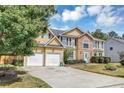 Spacious home with an attached two-car garage and long driveway, surrounded by mature trees and landscaping at 5115 Estonian Dr, Fairburn, GA 30213