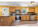 Cozy kitchen featuring stainless steel appliances, stone backsplash, and wood cabinetry with light countertops at 5115 Estonian Dr, Fairburn, GA 30213
