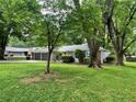 Single-story home with attached garage and beautiful lawn surrounded by mature trees at 215 Truehedge Trce, Roswell, GA 30076