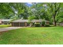 Lovely single-story home with attached garage, mature trees, and a well-maintained lawn at 215 Truehedge Trce, Roswell, GA 30076