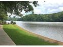 Scenic lake view featuring lush green grass and the edge of a sidewalk, perfect for lakeside strolls at 215 Truehedge Trce, Roswell, GA 30076