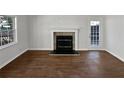 A bright and sunny living room with hardwood floors and a fireplace with white mantle at 4425 Amy Rd, Snellville, GA 30039