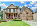 Charming two-story brick home with a welcoming covered front porch and a well-maintained lawn and front garden at 2612 Back Creek Chase, Dacula, GA 30019