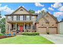 Charming two-story brick home featuring a well-manicured lawn, a welcoming covered porch and a two car garage at 2612 Back Creek Chase, Dacula, GA 30019