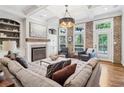 Elegant living room with a fireplace, built-in shelves, exposed brick wall, and coffered ceilings at 4588 Pine Se St, Smyrna, GA 30080