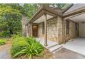 Inviting stone entrance featuring a charming wood door and professionally landscaped greenery at 2596 Midway Rd, Decatur, GA 30030