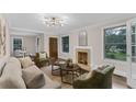 Bright living room features a cozy fireplace, a modern light fixture and a view to the dining area at 2596 Midway Rd, Decatur, GA 30030