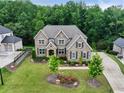A beautifully landscaped lawn surrounds this elegant home with a side entry garage at 3525 Montebello Pkwy, Cumming, GA 30028