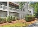 Exterior of multi-story condo building showing patios, siding, shrubbery, and walkway at 1931 Brian Way, Decatur, GA 30033