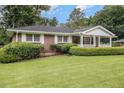Inviting brick home with a charming front porch and mature landscaping at 4125 Lindsey Dr, Decatur, GA 30035