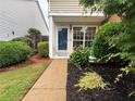 Inviting front entrance with lush landscaping and a well-manicured lawn at 1822 Commonwealth Dr, Woodstock, GA 30188