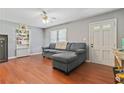 Cozy living room with hardwood floors, a comfortable couch, and a ceiling fan at 118 Greenwood St, Fairburn, GA 30213
