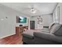 View of living room featuring hardwood floors, a sectional sofa, and a mounted television at 118 Greenwood St, Fairburn, GA 30213