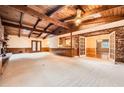 Spacious living room with exposed beam ceiling, brick fireplace, and access to dining area at 421 Fond Du Lac Dr, Stone Mountain, GA 30088
