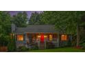 A charming house is seen at dusk, with its red front door and windows illuminated at 5761 E Emerald Oaks Ln, Acworth, GA 30102