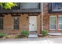 Charming brick townhome entrance with a white door, complemented by neat landscaping and clear address number at 7307 Cardigan Cir, Sandy Springs, GA 30328