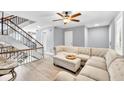 Bright, open-concept living area featuring a contemporary staircase and a plush sectional sofa at 7307 Cardigan Cir, Sandy Springs, GA 30328