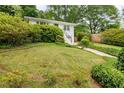 Alluring residence exhibits a lush front yard with mature trees, verdant lawn, and attached garage at 80 Vinson Se Dr, Atlanta, GA 30317