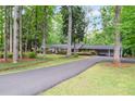 Picturesque brick home with long driveway surrounded by lush greenery and mature trees at 302 Chinquapin Sw Dr, Marietta, GA 30064