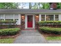 Inviting brick home entrance with a vibrant red front door and manicured shrubbery at 302 Chinquapin Sw Dr, Marietta, GA 30064