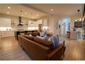 Open-concept living area with hardwood floors, a comfortable leather sofa, and views into the modern kitchen at 1122 Rice Nw St, Atlanta, GA 30318