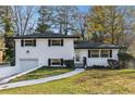 Charming white brick home featuring an attached garage and a beautifully maintained lawn at 2178 Shamrock Dr, Decatur, GA 30032