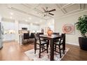 Dining area with coffered ceilings, hardwood floors, modern lighting, and stainless steel appliances in view at 84 Cedarcrest Village Ln, Acworth, GA 30101