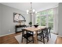 Bright dining room boasts a modern light fixture, minimalist decor, and a wall of windows at 1308 Fernwood Ne Cir, Atlanta, GA 30319
