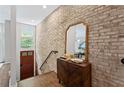 Inviting entryway featuring wood floors, exposed brick, cabinet with a decorative mirror creating an elegant ambiance at 1308 Fernwood Ne Cir, Atlanta, GA 30319