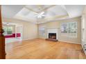 Bright living room boasting hardwood floors, a tray ceiling with fan, and a fireplace for cozy evenings at 2881 Bridle Creek Sw Dr, Conyers, GA 30094